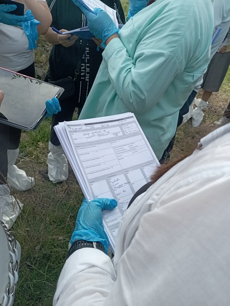 Researcher recording environmental sample data during fieldwork.