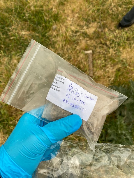 Labelled environmental sample bag held by a gloved researcher.