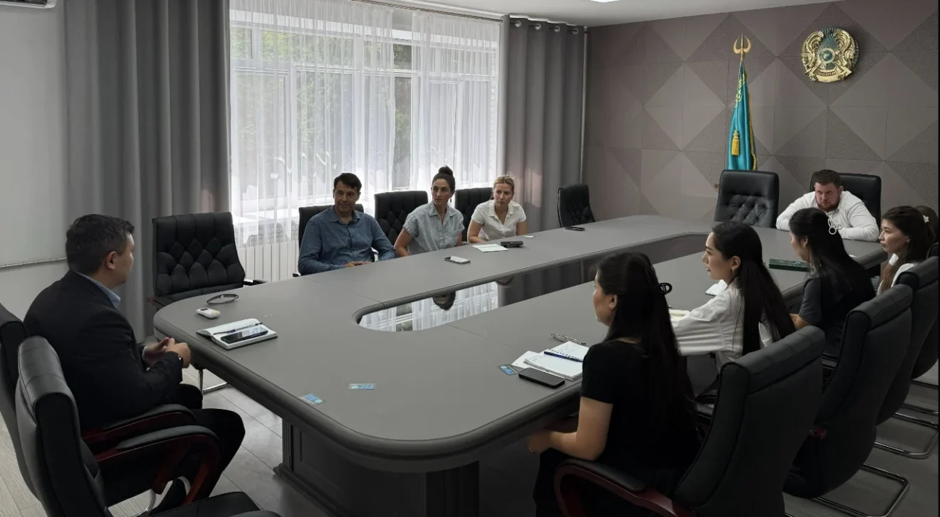 Research team meeting with East Kazakhstan environmental and public health officials around a conference table.